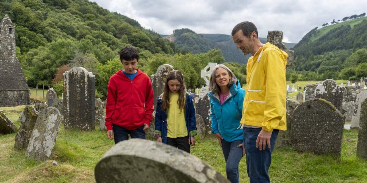 family looking at gravestone